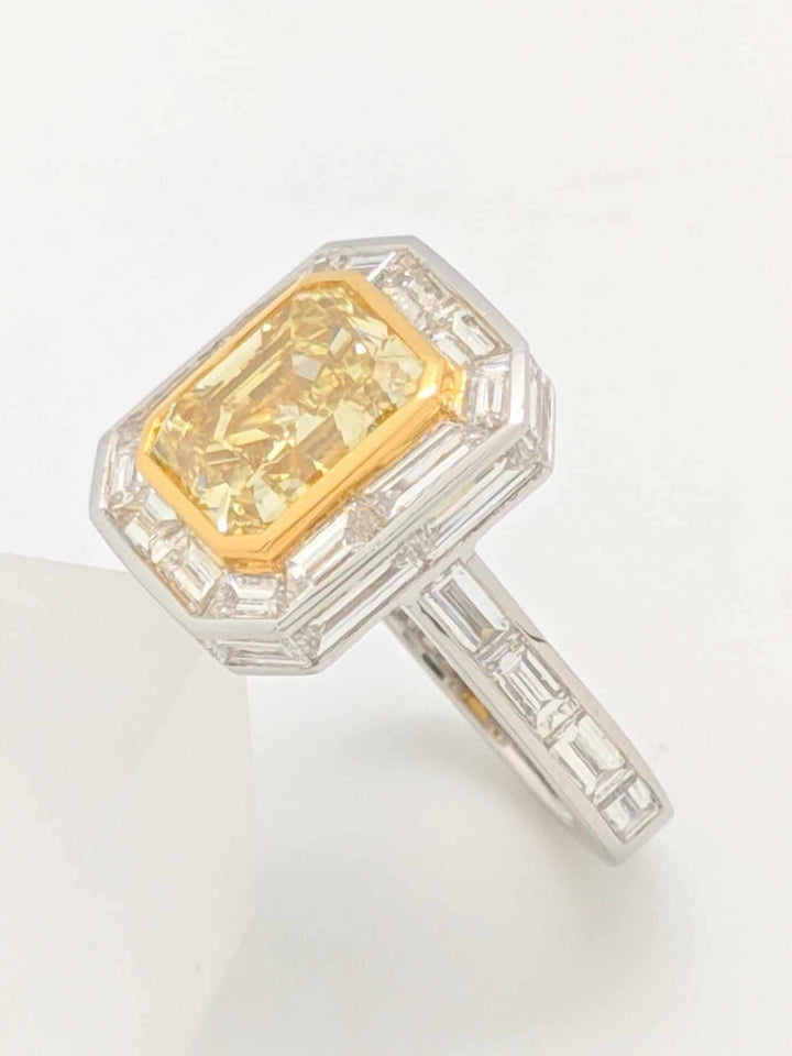 GIA Certified 5.01CT Emerald Cut Fancy Yellow Diamond Center Stone with Baguette Cut Diamond Halo Engagement Ring in Platinum