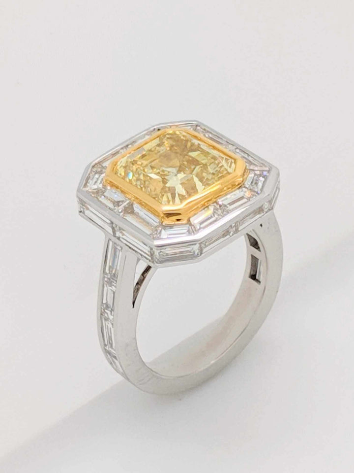 GIA Certified 5.01CT Emerald Cut Fancy Yellow Diamond Center Stone with Baguette Cut Diamond Halo Engagement Ring in Platinum