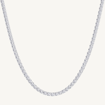 A white gold-toned tennis chain necklace paved with small clear stones, shown against a plain off-white background.
