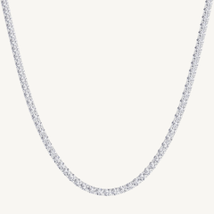 A white gold-toned tennis chain necklace paved with small clear stones, shown against a plain off-white background.