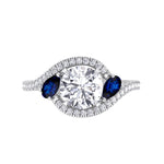 round-cut-diamond-engagement-ring-with-halo-and-blue-sapphire-pear-shape-sidestones-in-solid-white-gold
