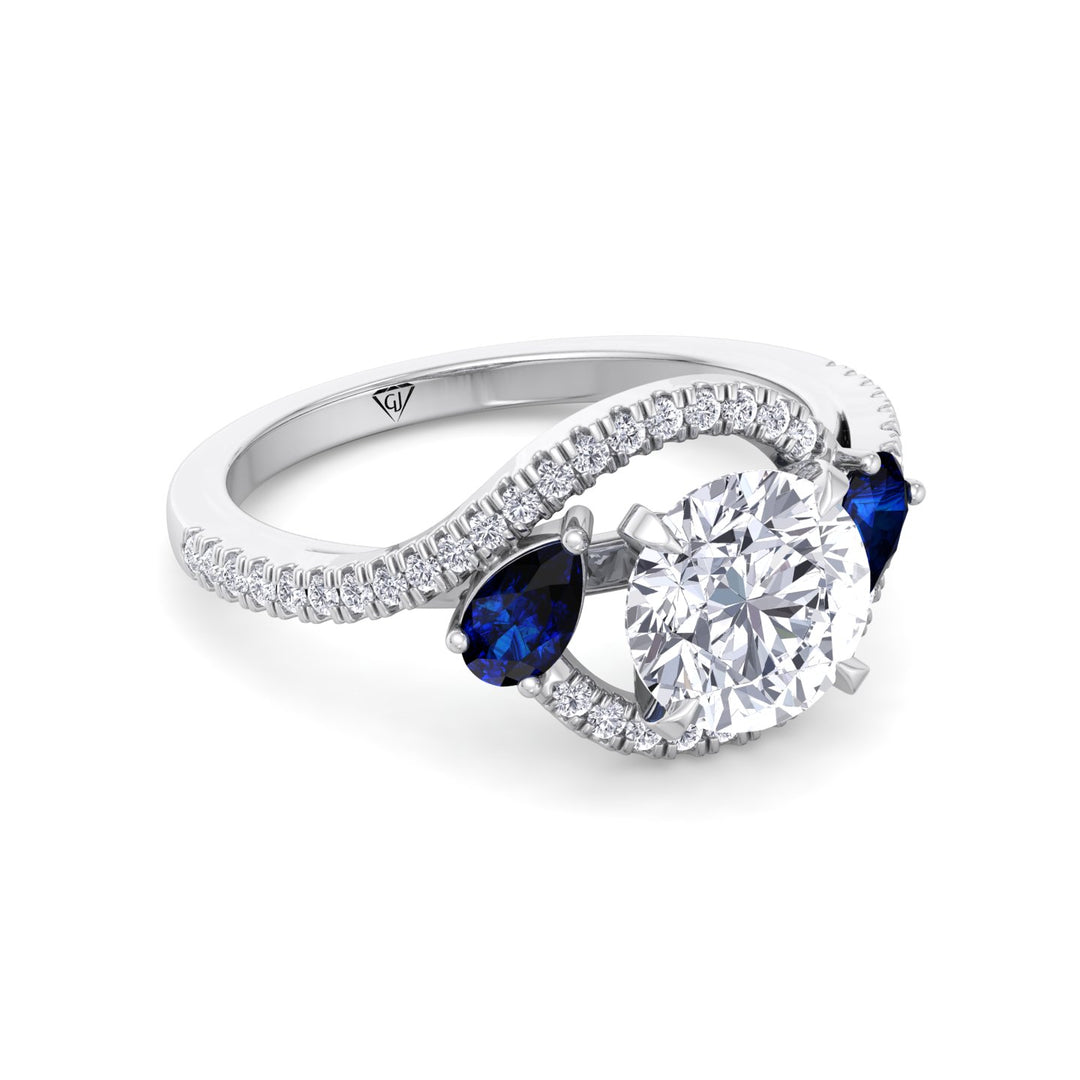 round-cut-diamond-engagement-ring-with-halo-blue-sapphire-pear-shape-sidestones-in-solid-white-gold