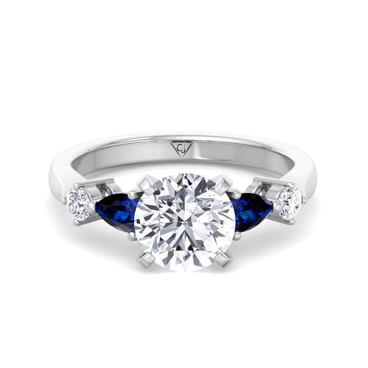 round-cut-diamond-engagement-ring-with-blue-sapphire-pear-shape-sidestones-in-platinum