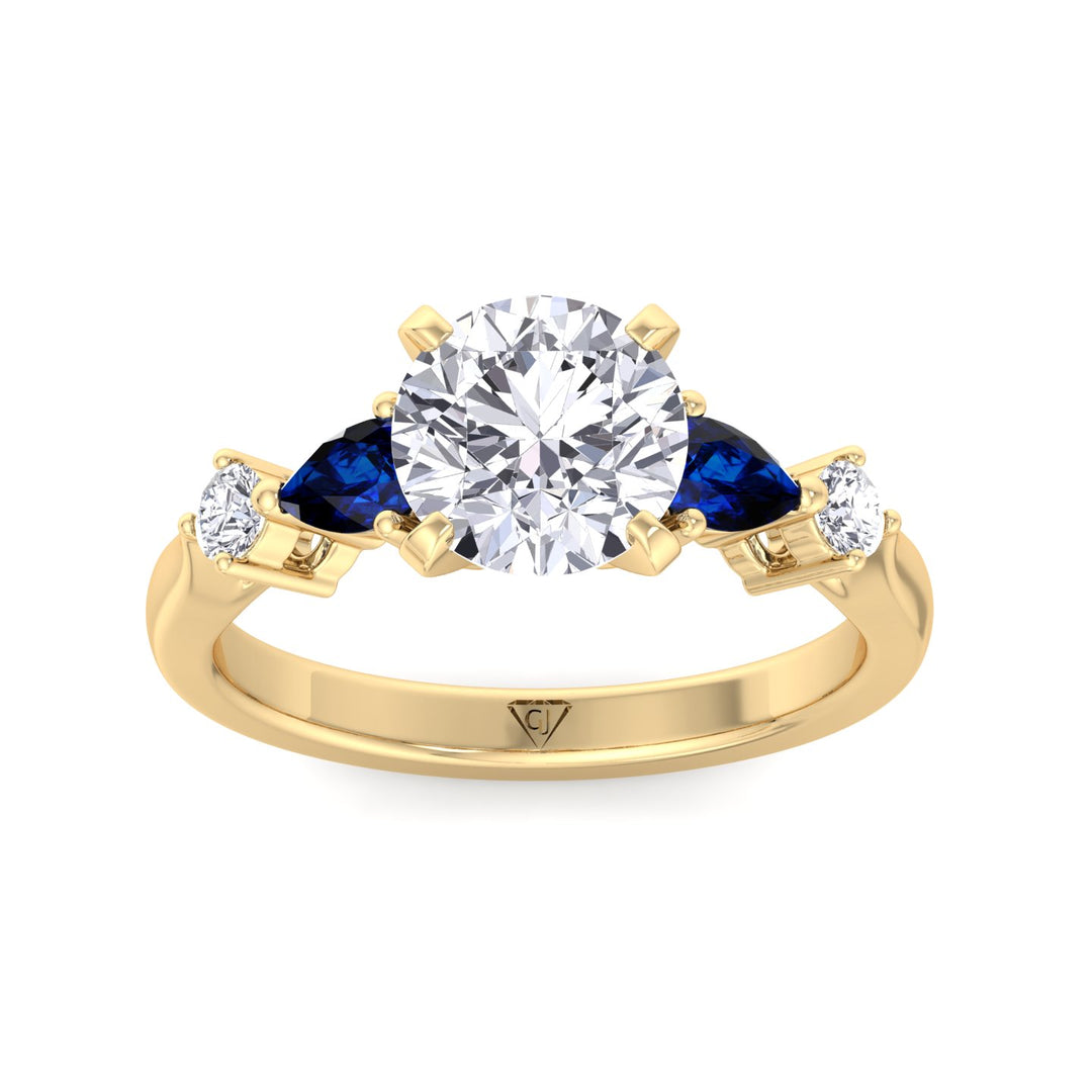 round-cut-diamond-engagement-ring-with-blue-sapphire-pear-shape-sidestones-in-solid-yellow-gold